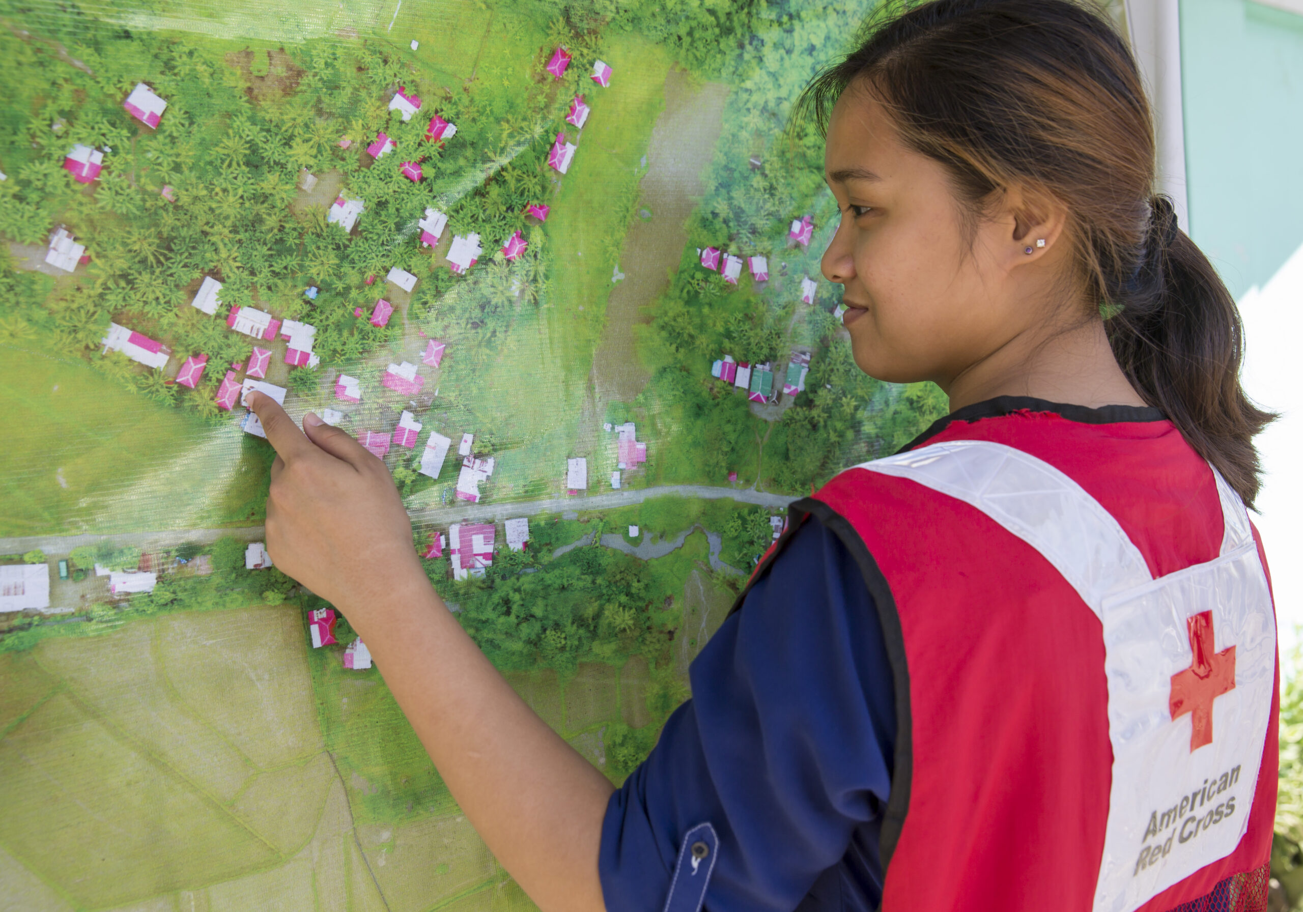 January 25, 2018. Danao, Leyte, Philippines. On the island of Leyte, in the Philippines, Red Cross teams and community leaders use crowd-sourced maps to verify evacuation routes, respond to disasters, and ensure that every household is cared for in case of emergency.  This map hangs outside the city hall and contains drone imagery. 

Each year, disasters around the world kill nearly 100,000 people and impact 200 million. Many of the places where these disasters occur are literally 'missing' from the digital mapso first responders lack the information to make decisions regarding relief efforts. Updated maps can expedite the delivery of emergency supplies, determine where help is needed most, and even track the spread of diseases like Ebola. Accurate maps can also help neighborhoods prepare for emergencies and make them less prone to natural disasters. Photo by Brad Zerivitz/American Red

Pictured: Ylla De Campo