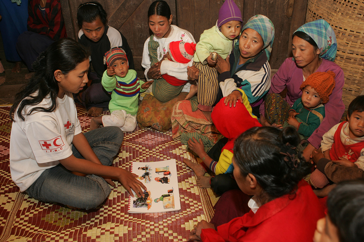 Date: November 2004    Event: Primary Health Care Project – Myanmar Red Cross Society    Photographer: Thorkell Thorkelsson    Release info: no release needed

Images from IFRC.

Pankala village 
The village is located about one hour and 15 minute walk from Sutywe village, which is on Keng Tung-Tachilek highway. There is no primary school in the village but children in the village can study up to grade 3 at a school whose teacher is appointed and paid by the village (Primary School is up to grade 5). Altogether 11 children learn at the school. Less than half of the children can go to school. There are 22 houses with 22 households. The total population is 106. Most villagers engage in farming. 
It is a Christian village and the majority of the villagers belong to Lahu ethnic group. The Keng Tung project renovated the water storage tank having 6 feet in diameter and 8 feet in height. 
It was day time when we arrived at village. During the health education session there were 14 people with only three men. That was the time when most people in the village were on their farms. Most of the participants were women, children and men who are not engaged in agriculture or who have got some other people to do the work.  There were some old men and women looking after their grandchildren. Khine Khine Yu, project assistant, told us that she had to inform in two-three days in advance for those who are engaged in farming to be present at the health education session. One man volunteered to act as an interpreter for the session. 
Project staff Htoo Hlaing (Mr.) and Khine Khine Yu (Ms.) mainly talked about personal hygiene and environmental problem. They emphasised on the importance of washing oneís hands before and after oneís meals and after washing oneís hands after one gets out from latrines. Water used from houses did not flow well and cow dung was seen here and there at the village. Khine Khine Yu tried to convince the villages to keep their environment clean. She explain