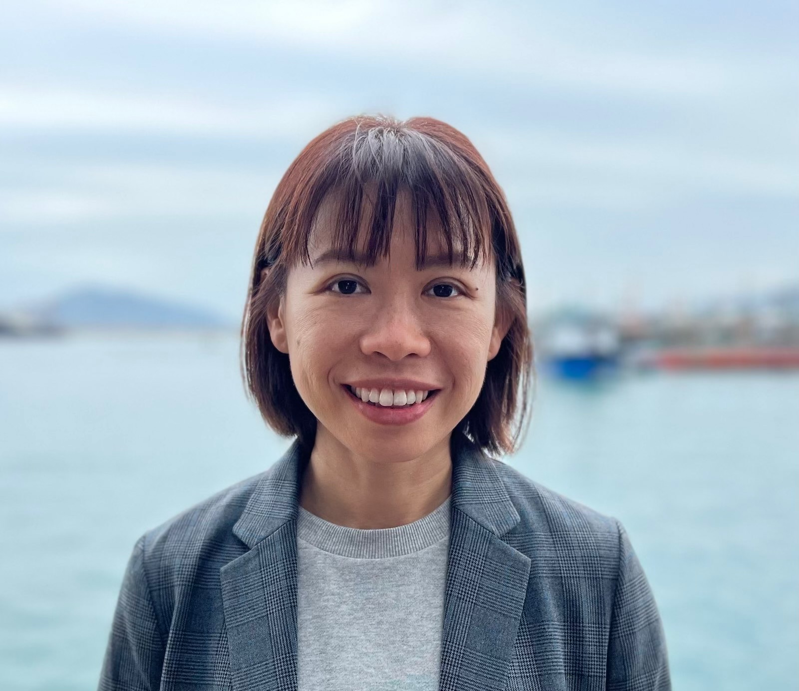 A portrait of Eva Yeung with the sea in the background.