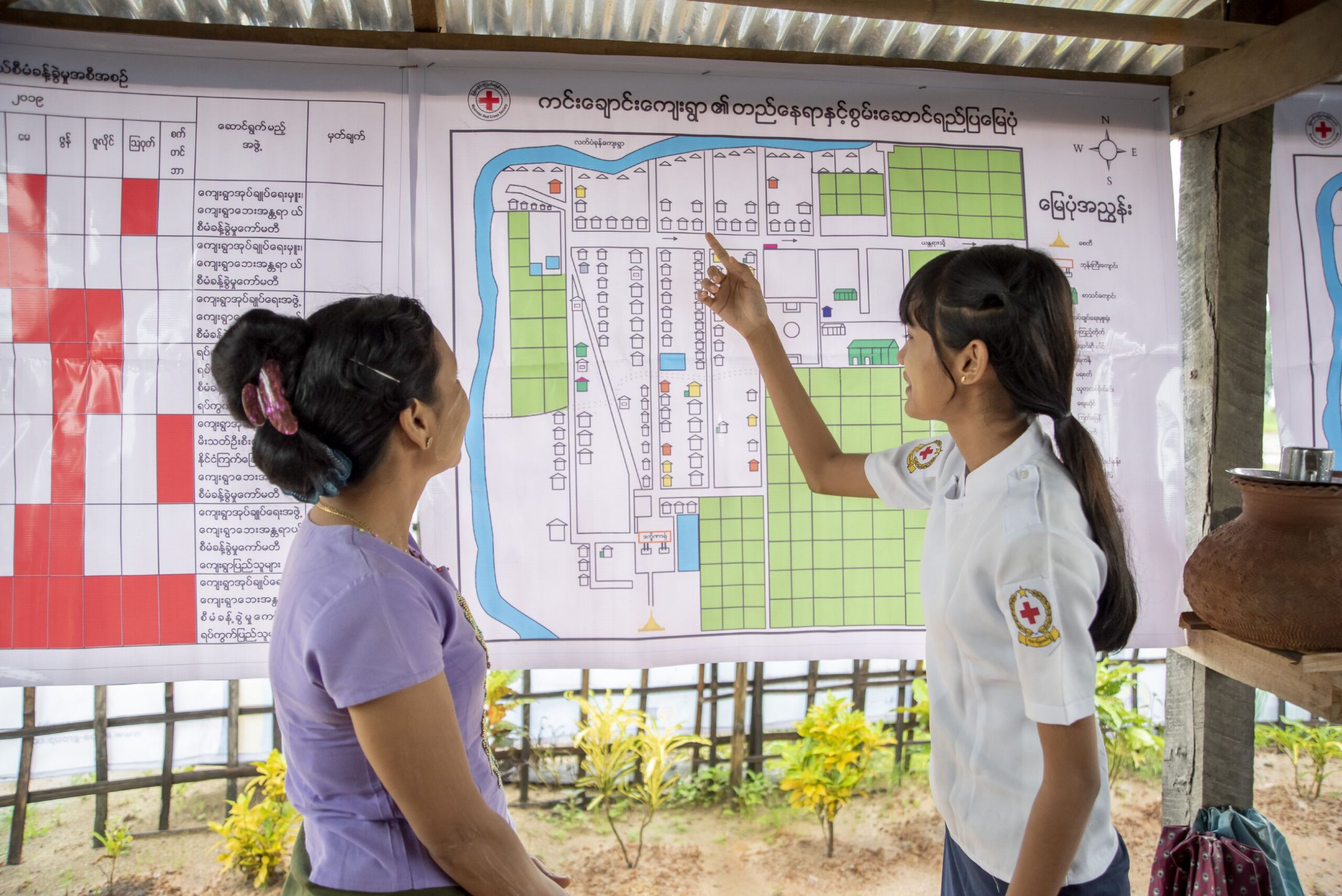Residents of Kim Chaung village, Myanmar, discuss a community map developed with the Red Cross, showing homes, evacuation routes, and safe spaces to shelter. Photo by Brad Zerivitz/American Red Cross. 