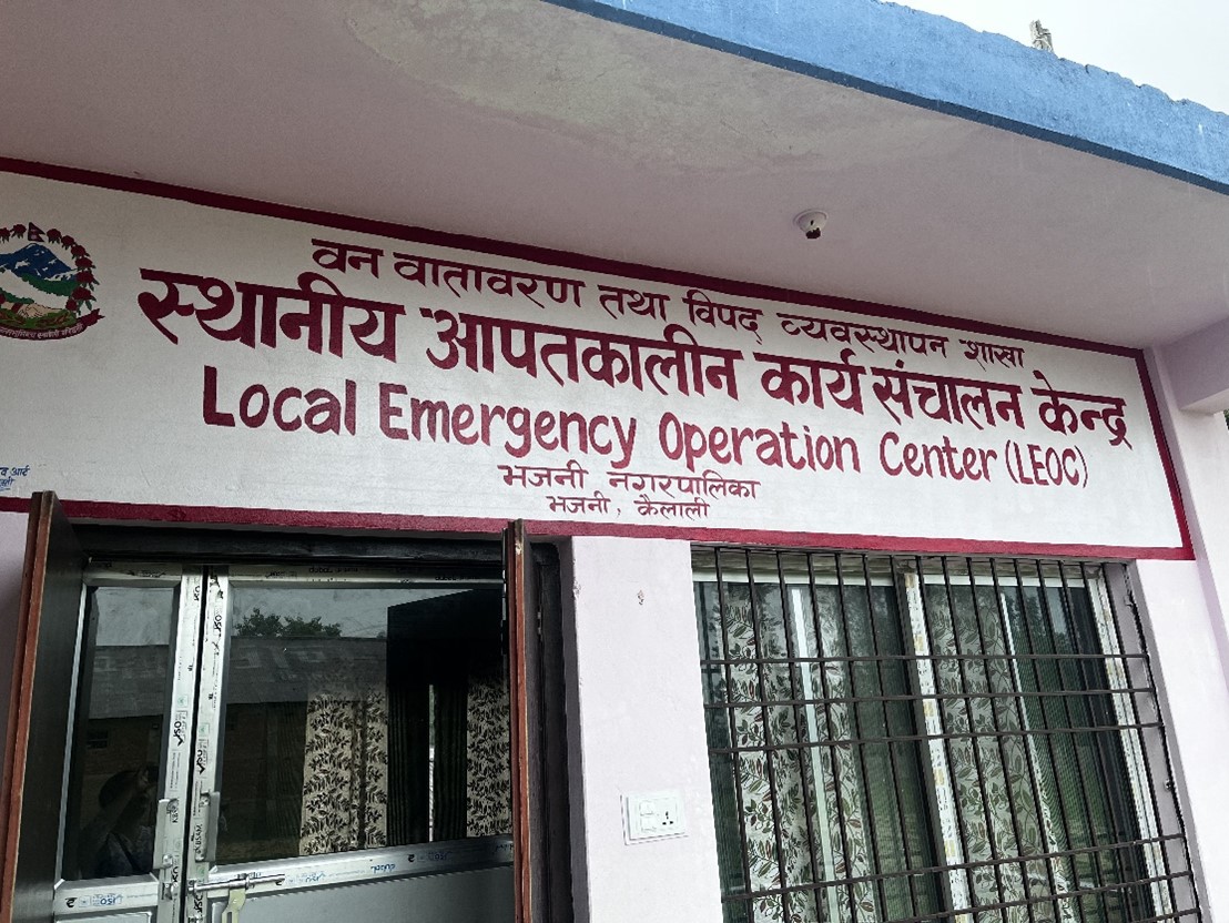 A building with a sign reading 'Local Emergency Operation Center (LEOC)' in both Nepali and English, located in Kailali district, Nepal.