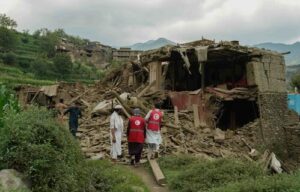Afghan Red Crescent Society volunteers survey the rubble of a collapsed mud-brick building following an earthquake in Afghanistan in August 2025.