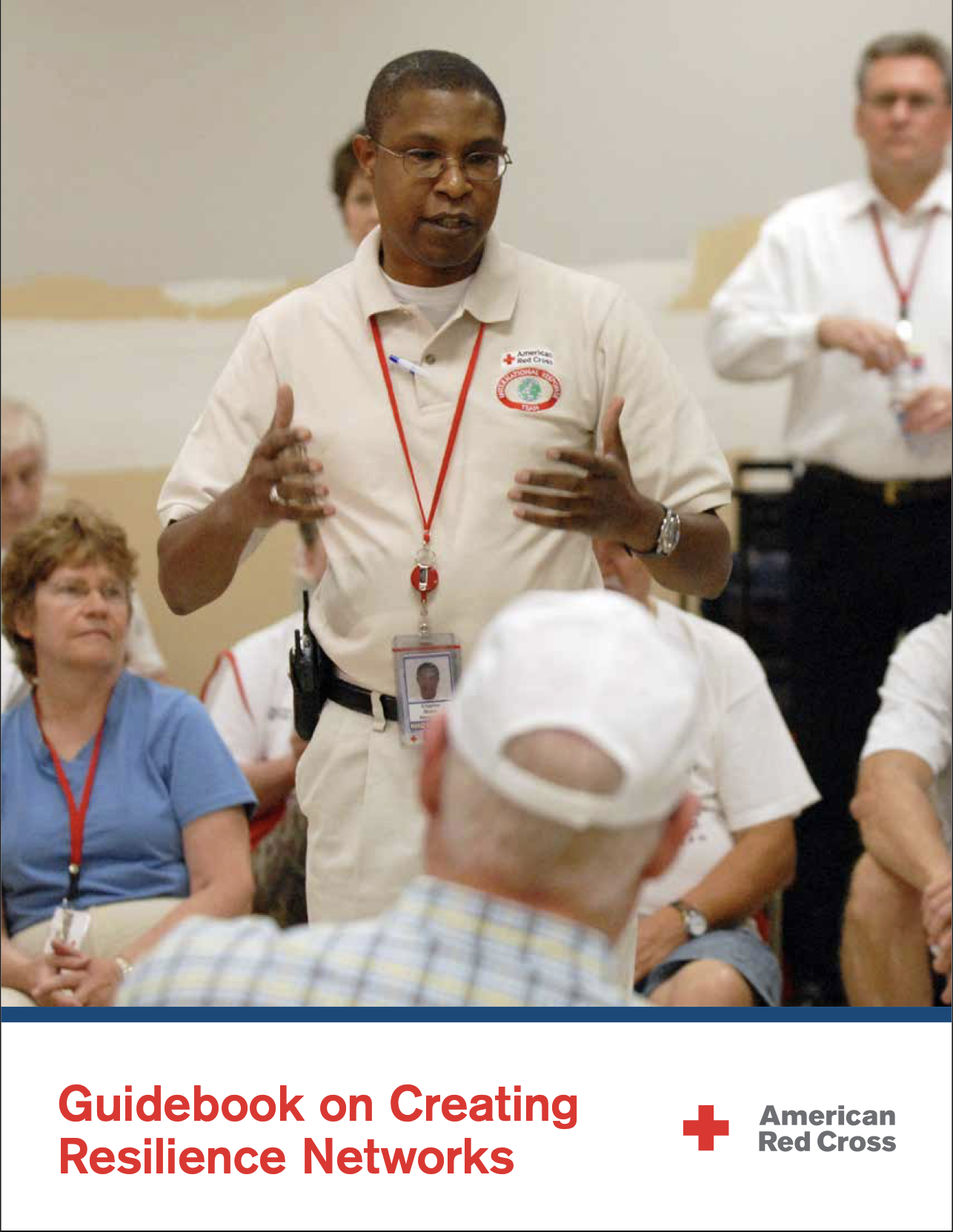 American Red Cross report cover titled 'Guidebook on Creating Resilience Networks.' The photo shows an American Red Cross staff member wearing a name badge and radio, gesturing with both hands while speaking to a seated group of volunteers and community members indoors.