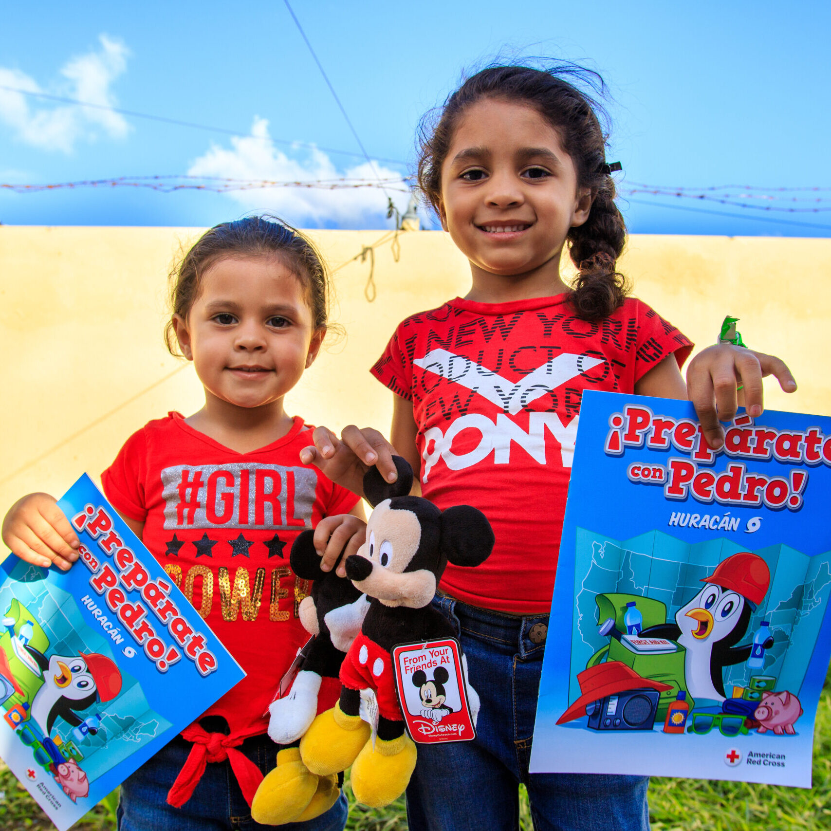 January 10, 2020. Refugio Ramón Baldorioty de Castro, Ponce, Puerto Rico. Sisters Reina Liz standing on the left, and Joslianys, standing on the right, told us how they participated in the Prepare with Pedro workshop and received a Mickey Mouse doll. Photo by Isaac León/American Red Cross
