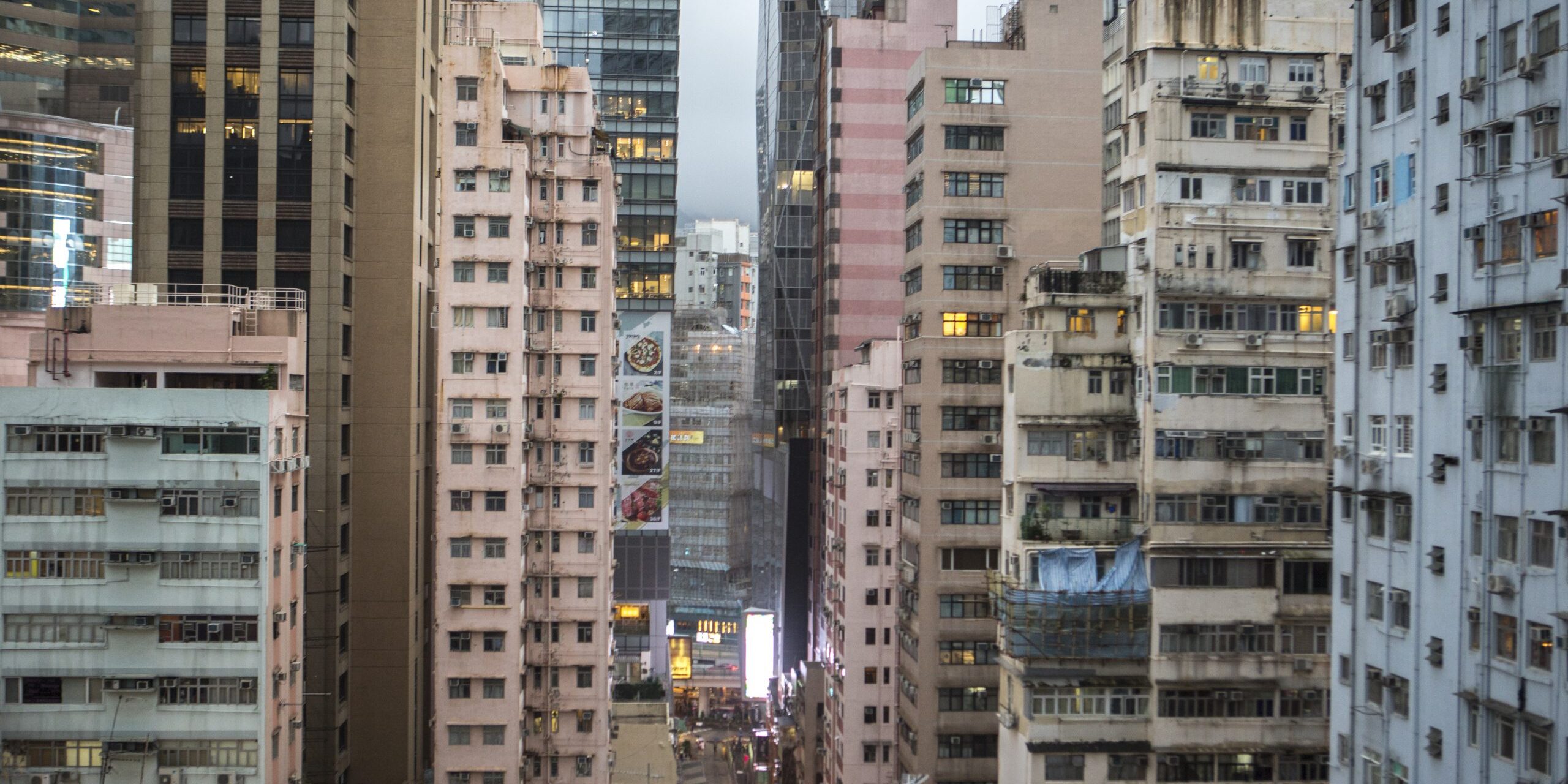 According to studies conducted by the Hong Kong Observatory, urbanization contributes about 50% of the warming in cities like Hong Kong. Concrete buildings store heat in the day and release it in the night, unbalancing the normal day and night cooling cycle. in addition, tall building block air circulation and reduce wind speed.