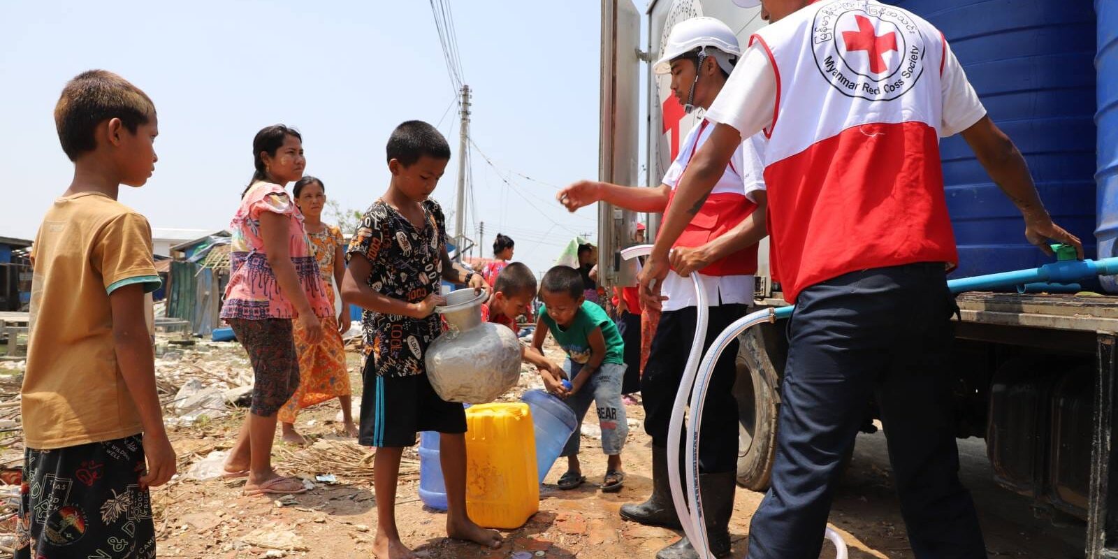 Myanmar Red Cross volunteers provide drinking water to children in communities affected by Cyclone Mocha